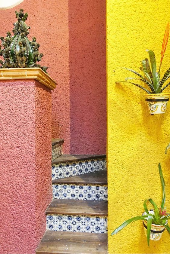 Inspiration photo: pink and yellow plaster walls around a tiled stair